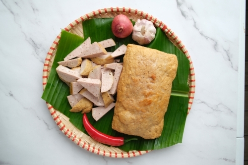 Fried Vietnamese ham served in a banana leaf inside a woven plate. - Australian Stock Image
