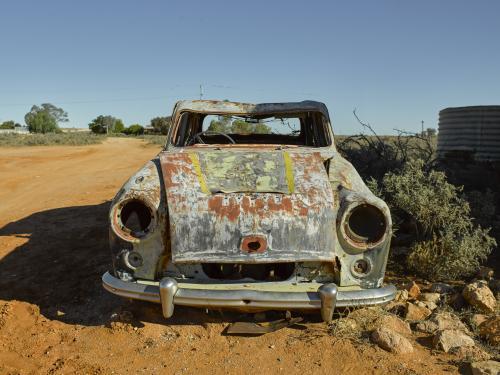 Front on shot of a rusty car in outback