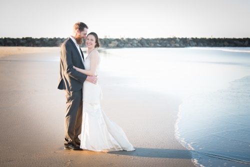 Full length image of young couple on wedding day at beach. - Australian Stock Image