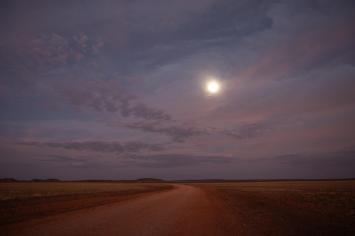 Full moon lighting up a dirt road - Australian Stock Image