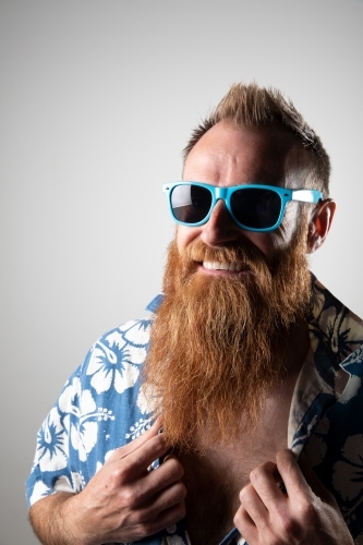 Funky man in a blue floral shirt posing for photographs - Australian Stock Image