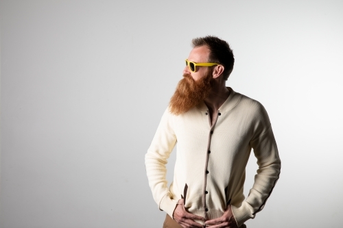 Funky man posing for photographs, wearing a beige shirt - Australian Stock Image
