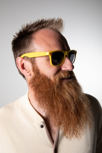 Funky man posing for photographs, wearing a beige shirt - Australian Stock Image