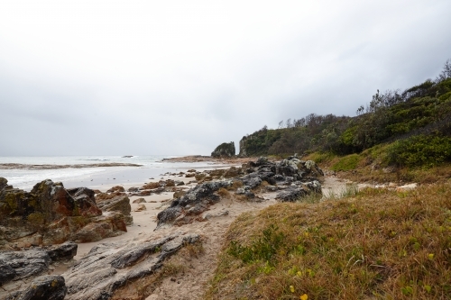 Gap in coastal rocky headland landscape on overcast morning - Australian Stock Image