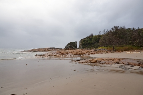 Gap in coastal rocky headland landscape on overcast morning - Australian Stock Image