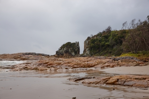 Gap in coastal rocky headland landscape on overcast morning - Australian Stock Image