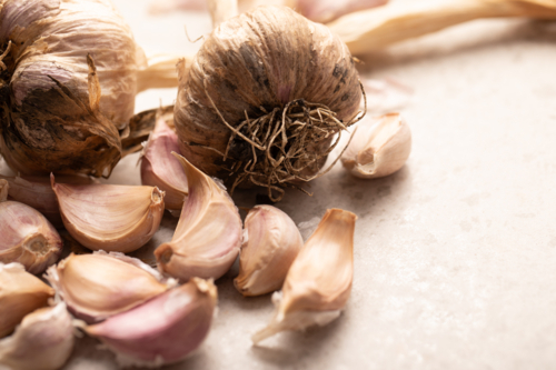 Garlic bulb and cloves on stone benchtop - Australian Stock Image