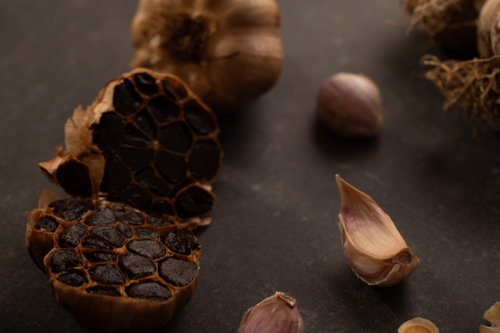 Garlic bulb cut in half to show smoked cloves - Australian Stock Image