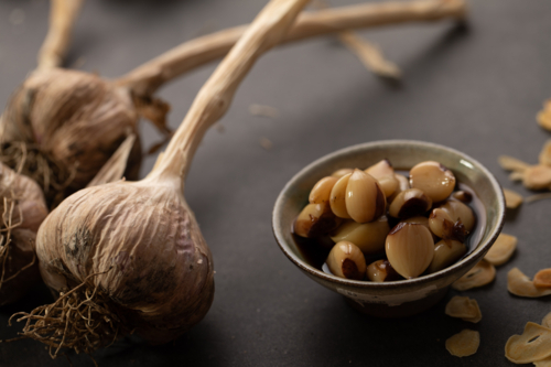 Garlic bulb with cloves on dark benchtop - Australian Stock Image