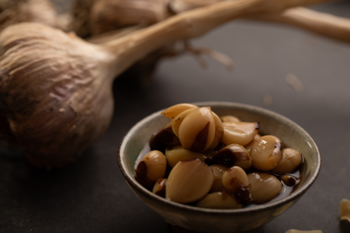 Garlic bulb with cloves on dark benchtop - Australian Stock Image