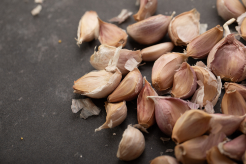 Garlic cloves on dark benchtop - Australian Stock Image
