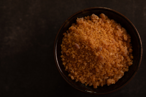 Garlic salt in bowl on dark surface - Australian Stock Image