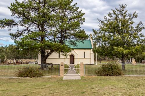 Gate and trees in front of a country church on a overcast day - Australian Stock Image
