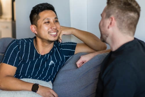 gay asian man smiling at his boyfriend - Australian Stock Image