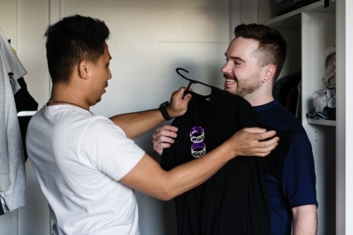 gay man choosing an outfit for his boyfriend - Australian Stock Image