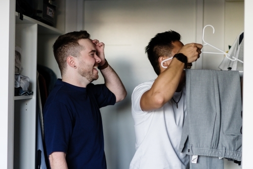 gay man choosing an outfit for his boyfriend - Australian Stock Image