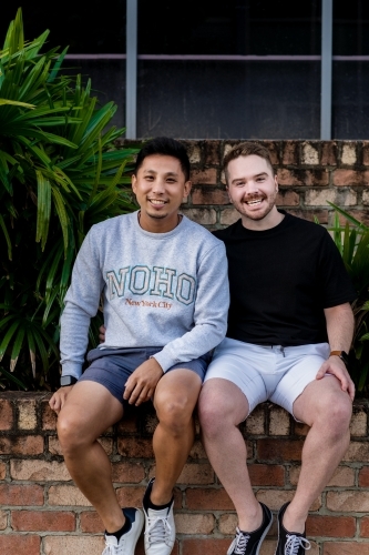 gay men sitting outside, smiling - Australian Stock Image