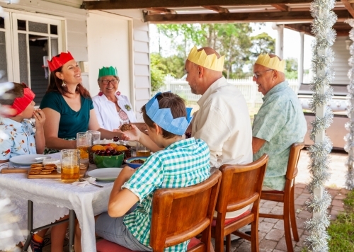 Generations of Australian family together at Christmas eating dessert in backyard - Australian Stock Image