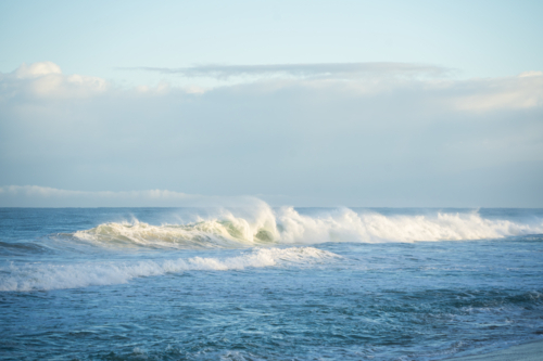 Gentle ocean waves breaking near sand shoreline at Scarborough Beach, Perth, Western Australia - Australian Stock Image