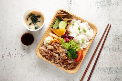 Ginger pork bento dish with miso soup - Australian Stock Image