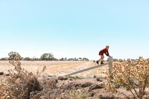 Girl climbing on fence in rural Australia - Australian Stock Image
