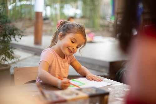 Girl drawing in early education setting - Australian Stock Image