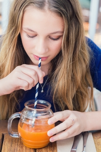 girl drinking juice at cafe - Australian Stock Image