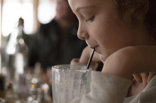 Girl drinks milkshake through a straw