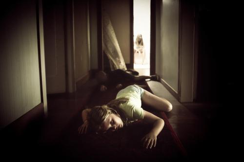 Girl fallen in hallway - creepy - Australian Stock Image