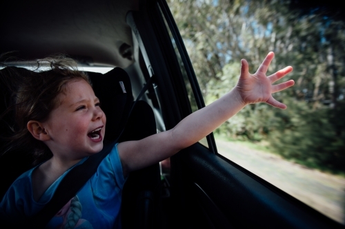 Girl feeling the wind out the car window - Australian Stock Image