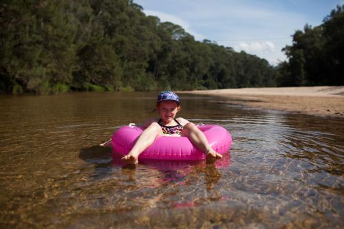 Girl floating on a river in an inflatable ring - Australian Stock Image