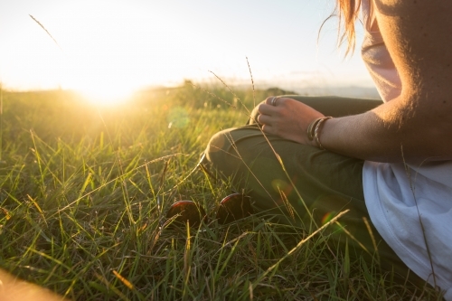 Girl getting warmth from the last light of the day - Australian Stock Image