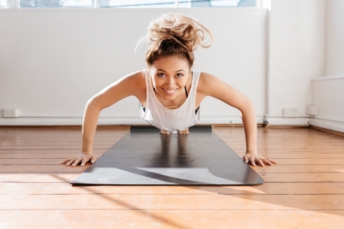 Girl half way down doing a push up - Australian Stock Image