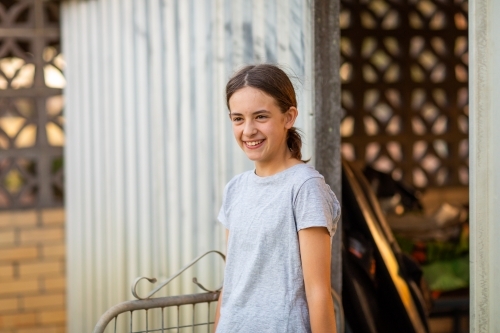 girl in grey t-shirt entering yard from shed