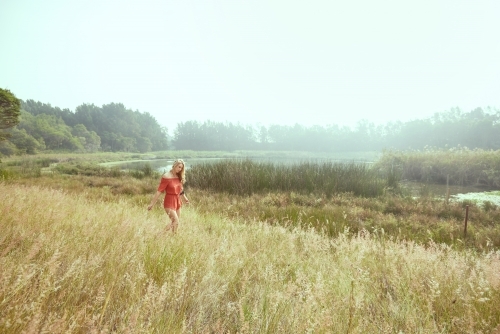 Girl in red walking in nature in a vintage style - Australian Stock Image