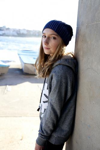 Girl leaning against wall by the seaside - Australian Stock Image