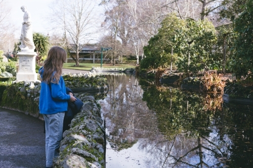 Girl looking into reflections at Ballarat Botanical Garden - Australian Stock Image