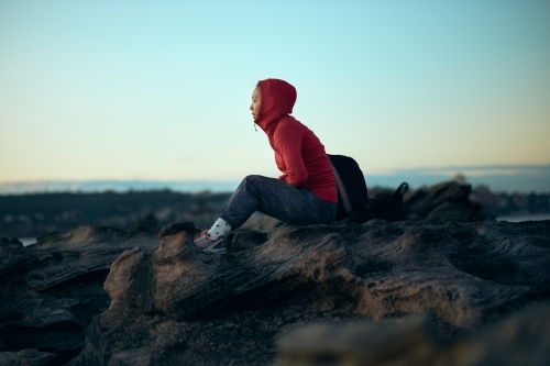 Girl looking out to ocean in winter with active wear