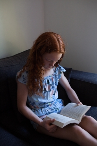 Girl reading a book on a lounge