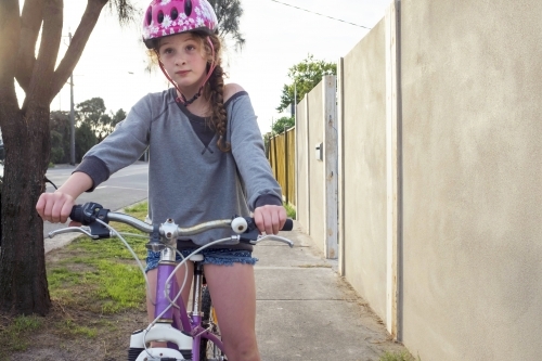 Girl riding bike along urban street.