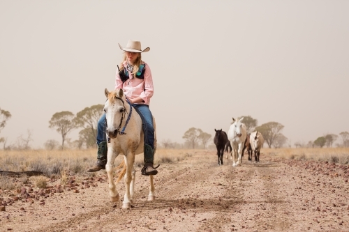 Girl Riding Pony on a dirt track - Australian Stock Image