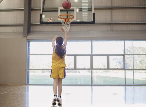 girl shooting basketball hoop. - Australian Stock Image