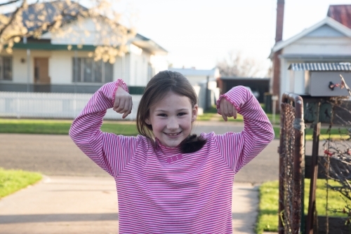 Girl showing her strength off while posing. - Australian Stock Image