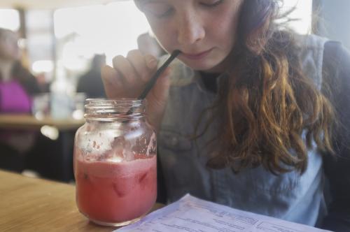 Girl sips watermelon juice in cafe - Australian Stock Image