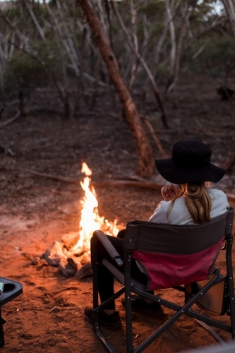 Girl sitting by campfire - Australian Stock Image