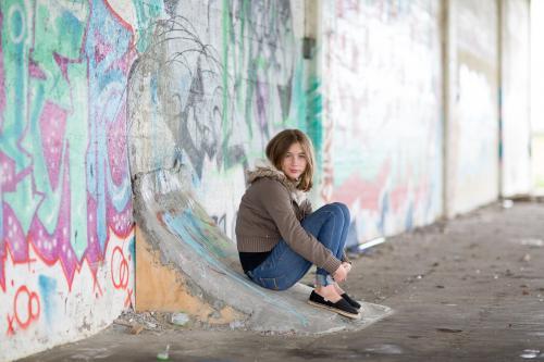 Girl sitting on ramp with graffiti