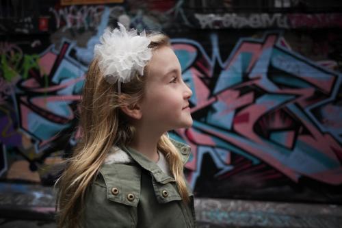 Girl standing in the street in front of graffiti looking up - Australian Stock Image