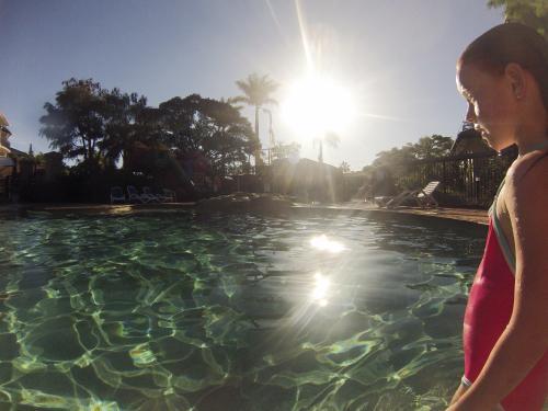 Girl standing on the side of a swimming pool - Australian Stock Image