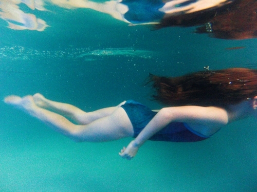 Girl swimming underwater in a pool - Australian Stock Image