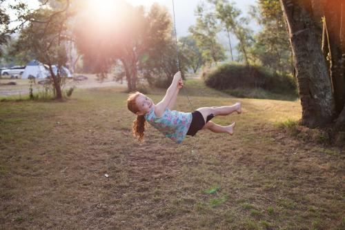 Girl swinging on a rope swing - Australian Stock Image
